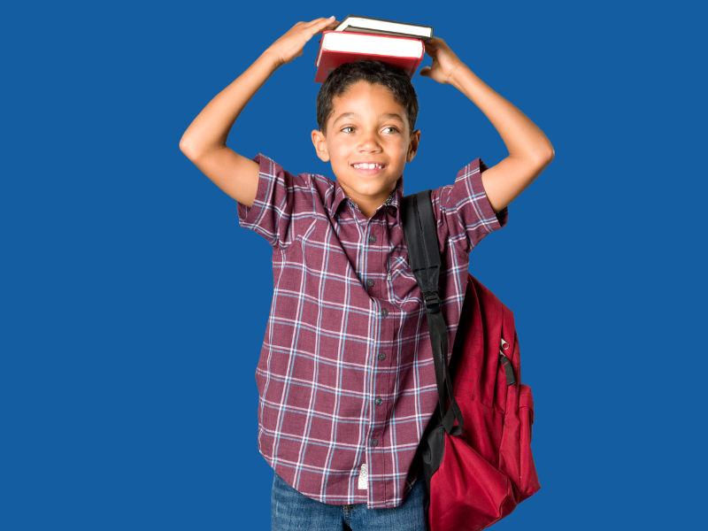 A school-age child smiling with a backpack