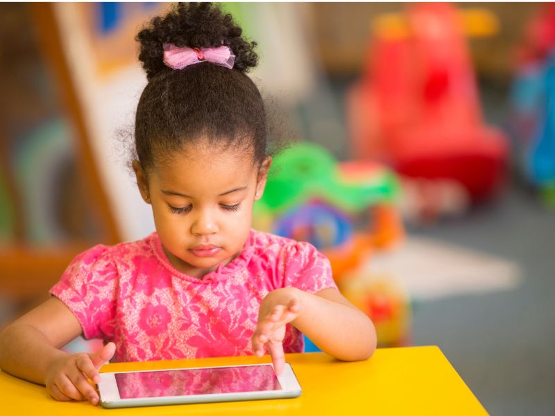 A preschooler exploring a learning tablet activity