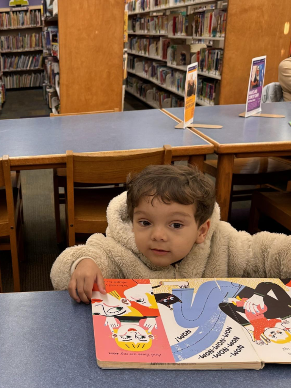 A toddler turning the pages of a colorful board book